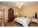 Bedroom features wood-look floors, ceiling fan, and furnishings with view to the en-suite bathroom at 40 Gretchen Ct, Oldsmar, FL 34677