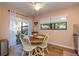 Cozy dining area features a round wooden table, cream chairs, and views of the outdoors through sliding glass doors at 40 Gretchen Ct, Oldsmar, FL 34677