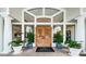 Grand entrance doors showcasing intricate wood carvings, flanked by potted plants, welcoming guests to Ardea at 40 Gretchen Ct, Oldsmar, FL 34677