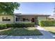 Charming front exterior featuring a well-manicured lawn, hedges, and inviting entrance in a cozy community at 40 Gretchen Ct, Oldsmar, FL 34677
