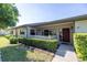 Charming home with manicured front lawn, neatly trimmed hedges, and a cozy porch area with a red front door at 40 Gretchen Ct, Oldsmar, FL 34677