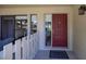 Inviting front porch with a red front door and white picket fence and view into the living area at 40 Gretchen Ct, Oldsmar, FL 34677