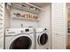 Convenient laundry room with washer, dryer, and shelves for organized storage at 40 Gretchen Ct, Oldsmar, FL 34677