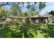 Backyard view of a lush, manicured yard with seating and shade, perfect for relaxation and entertaining at 4414 W El Prado Blvd, Tampa, FL 33629