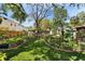 Backyard featuring manicured artificial turf, lush landscaping, and a charming outdoor seating area at 4414 W El Prado Blvd, Tampa, FL 33629