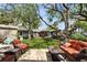 Relaxing backyard with a patio, seating area, artificial turf, and mature trees creating shade at 4414 W El Prado Blvd, Tampa, FL 33629