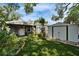 Backyard showcasing artificial turf, landscaping, and a storage shed near a cozy outdoor seating area at 4414 W El Prado Blvd, Tampa, FL 33629