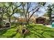 Beautifully landscaped backyard featuring a tiki bar, outdoor kitchen, and lush greenery for outdoor enjoyment at 4414 W El Prado Blvd, Tampa, FL 33629