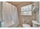 Bright bathroom with a shower, a window and blind, a toilet, and neutral-toned tile walls at 4414 W El Prado Blvd, Tampa, FL 33629