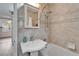 This bathroom includes a tiled shower and tub, a sink on a pedestal and a mirrored cabinet at 4414 W El Prado Blvd, Tampa, FL 33629
