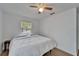 A bedroom featuring hardwood floors, a ceiling fan, a window, and a bed with white bedding at 4414 W El Prado Blvd, Tampa, FL 33629
