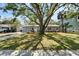 View of the house exterior with a large front yard shaded by a mature tree at 4414 W El Prado Blvd, Tampa, FL 33629