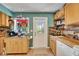 Kitchen showcases wooden cabinetry, stainless steel appliances, and natural light from the door at 4414 W El Prado Blvd, Tampa, FL 33629