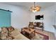 Cozy living room featuring a tan couch, wood coffee table, ceiling fan, and wall-mounted TV at 4414 W El Prado Blvd, Tampa, FL 33629