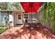 Inviting outdoor patio featuring table and chairs under a red umbrella, perfect for relaxing at 4414 W El Prado Blvd, Tampa, FL 33629