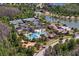 An aerial view showcases the community amenities, with the pool, tennis courts, and lake set in a green landscape at 4663 Almada Ln, Wesley Chapel, FL 33543