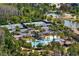 Beautiful aerial view of a community pool, tennis courts, and a pond surrounded by lush green trees at 4663 Almada Ln, Wesley Chapel, FL 33543