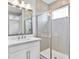 Bathroom vanity with large mirror and glass shower doors at 4663 Almada Ln, Wesley Chapel, FL 33543