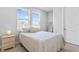Well-lit bedroom with a comfortable bed, bedside table, and natural light from large windows at 4663 Almada Ln, Wesley Chapel, FL 33543
