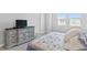Bedroom featuring a dresser, a bed with decorative pillows, and natural light from the windows at 4663 Almada Ln, Wesley Chapel, FL 33543