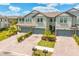 Two-story townhome showing garages, landscaping and brick paver driveway at 4663 Almada Ln, Wesley Chapel, FL 33543