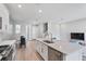 Spacious kitchen with stainless steel appliances, a large island with a sink, and an open view to the living area at 4663 Almada Ln, Wesley Chapel, FL 33543