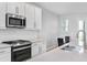 Bright kitchen featuring white cabinets, quartz countertops, stainless steel appliances, and a subway tile backsplash at 4663 Almada Ln, Wesley Chapel, FL 33543