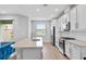 Bright kitchen featuring white cabinets, quartz countertops, stainless steel appliances, and an open view to the living area at 4663 Almada Ln, Wesley Chapel, FL 33543