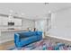 Bright living room with kitchen access and modern decor, hardwood floors, staircase and blue couch at 4663 Almada Ln, Wesley Chapel, FL 33543