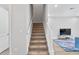 Stairway with carpet steps and white railings leading to the upper level and adjacent to the living room area at 4663 Almada Ln, Wesley Chapel, FL 33543