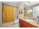 Bathroom featuring a granite countertop, cherry wood cabinets, and a shower with patterned tile at 47 W Morgan St, Tarpon Springs, FL 34689