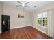 Bright bedroom featuring hardwood floors, a ceiling fan, and a large window with a balcony view at 47 W Morgan St, Tarpon Springs, FL 34689