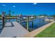 Boat lift with a covered boat on the water, alongside a wooden dock and lush green grass at 47 W Morgan St, Tarpon Springs, FL 34689