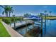 Boat lift on the water with a covered boat, surrounded by greenery and palm trees at 47 W Morgan St, Tarpon Springs, FL 34689