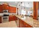 Modern kitchen featuring stainless steel appliances, granite countertops, and wood cabinetry at 47 W Morgan St, Tarpon Springs, FL 34689