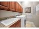 Laundry room with dark wood cabinets, granite countertops, and a white washer and dryer at 47 W Morgan St, Tarpon Springs, FL 34689