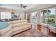 Open living room with hardwood floors, balcony view, comfortable white sofa and light blue accents at 47 W Morgan St, Tarpon Springs, FL 34689