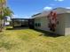 Backyard with lawn and view of screened in patio at 4908 Babbling Brook Ln, Wimauma, FL 33598