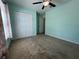 This bedroom features a ceiling fan and a closet for storage at 4908 Babbling Brook Ln, Wimauma, FL 33598