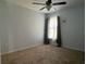 Bright bedroom featuring a ceiling fan, large window, and neutral carpet at 4908 Babbling Brook Ln, Wimauma, FL 33598