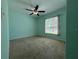 This bedroom features a ceiling fan and a window that brings in natural light at 4908 Babbling Brook Ln, Wimauma, FL 33598