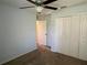 Neutral bedroom with ceiling fan, double closets, and carpeted floors at 4908 Babbling Brook Ln, Wimauma, FL 33598