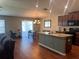 Well-lit kitchen features an island with granite countertops, dark wood cabinetry, and appliances at 4908 Babbling Brook Ln, Wimauma, FL 33598