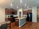 Well-equipped kitchen with stainless steel appliances, granite counters, island, and adjacent dining space at 4908 Babbling Brook Ln, Wimauma, FL 33598
