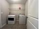 Laundry room featuring tile floors, washer, dryer, and wire shelving at 4908 Babbling Brook Ln, Wimauma, FL 33598