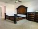 Bedroom showcases a dark wood bed frame and a matching dresser on neutral carpet flooring at 4908 Babbling Brook Ln, Wimauma, FL 33598