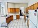 Bright kitchen featuring wood cabinets, white appliances, and tile floors offers a functional design at 4942 Oldham St, Sarasota, FL 34238