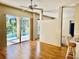Bright living room boasts wood floors, ceiling fan, and sliding glass doors to a screened patio and pool at 4942 Oldham St, Sarasota, FL 34238