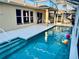 A pristine pool with crystal-clear water, surrounded by a screened enclosure, and a clean white patio, perfect for relaxation at 4942 Oldham St, Sarasota, FL 34238