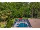 Overhead view of a screened-in pool with an attached spa and an umbrella-covered deck at 5004 Waterkey Way, Tampa, FL 33647